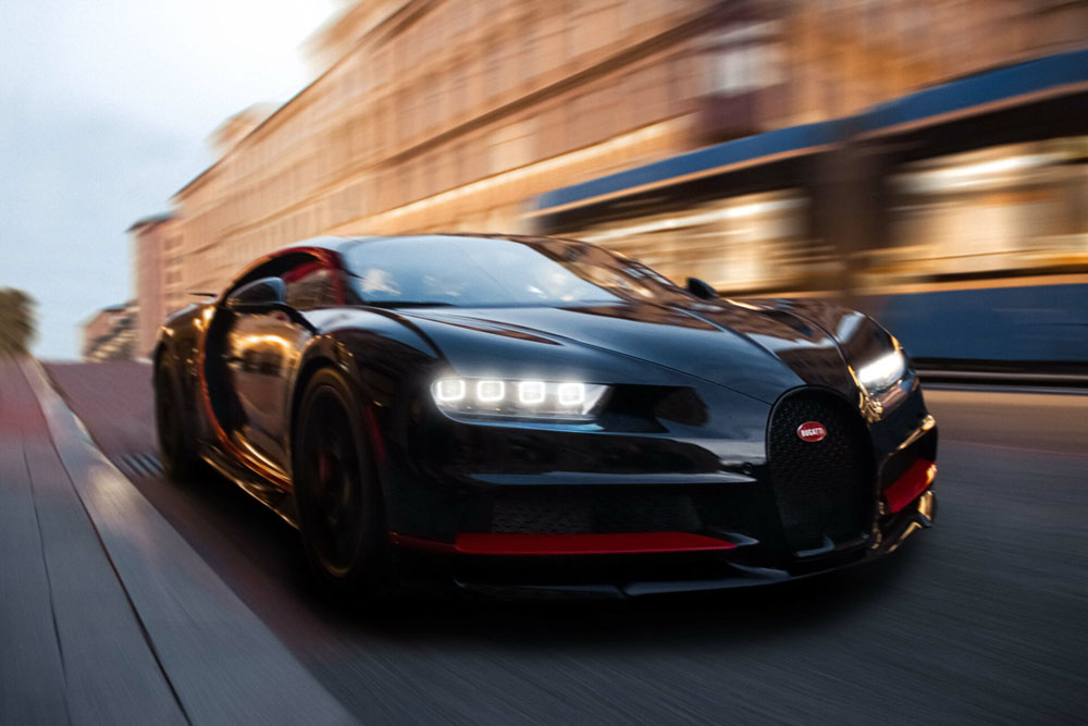Schwarzer Bugatti Sportwagen dynamisch in der Stadt